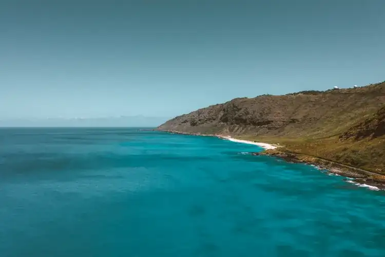 Aerial view of the Oahu coastline with clear blue water and sand, Hawaii
