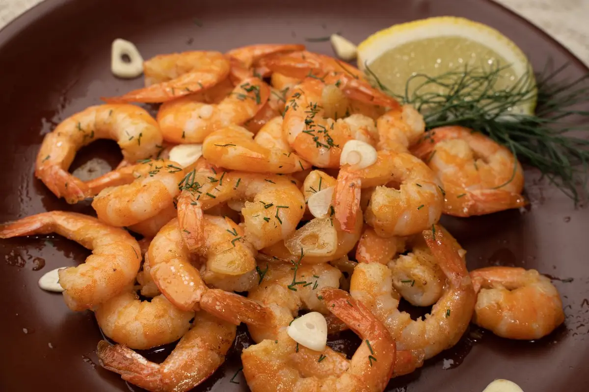 A plate of Hawaiian style garlic shrimp with lemon