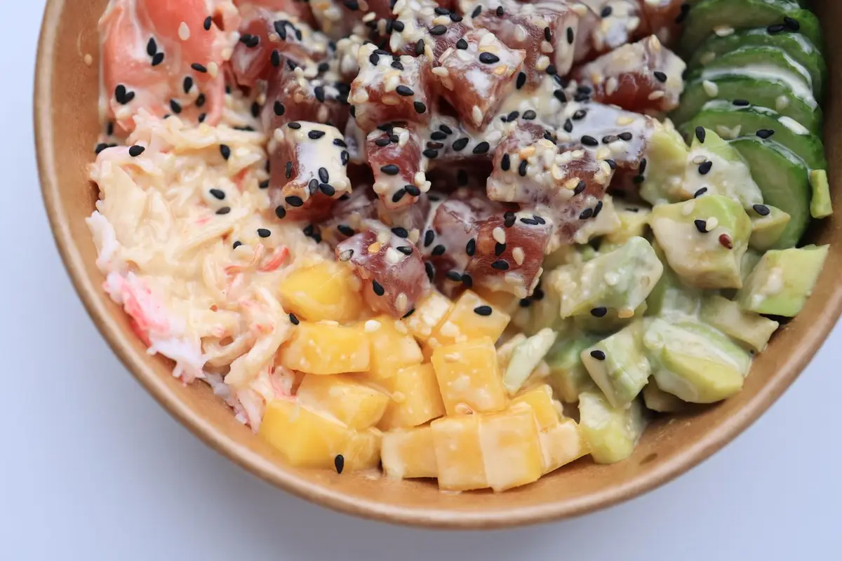 A Hawaiian style poke bowl with cubed ahi, mango, avocado, and sesame
