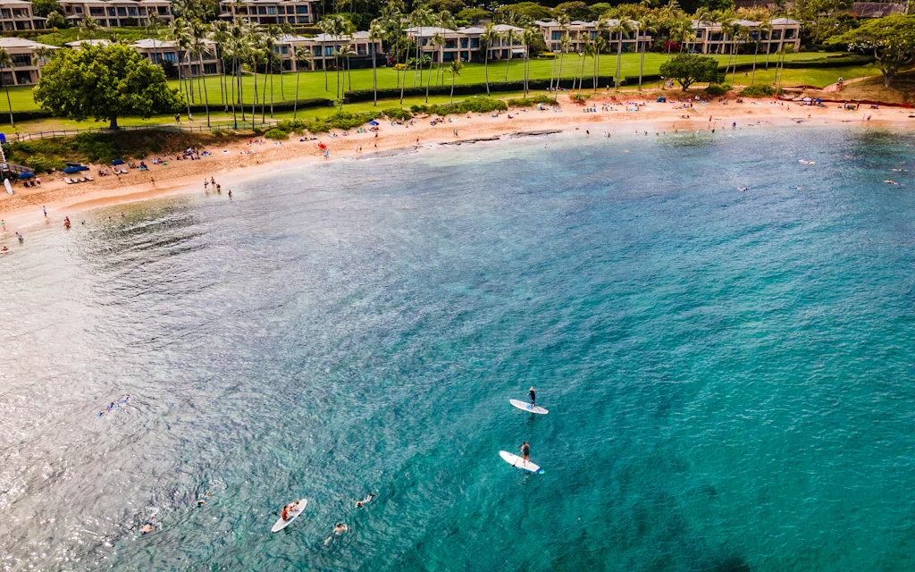 Best time to visit Maui - a sunny turquoise Maui beach with paddleboarders offshore