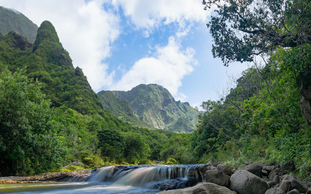 A green Hawaiian valley with a waterfall, like Iao Valley on Maui