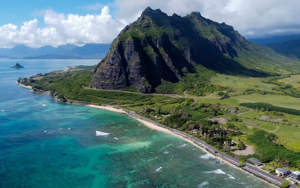 The green Koolau mountains rising over the bright blue water of Kaneohe Bay on the windward side of Oahu