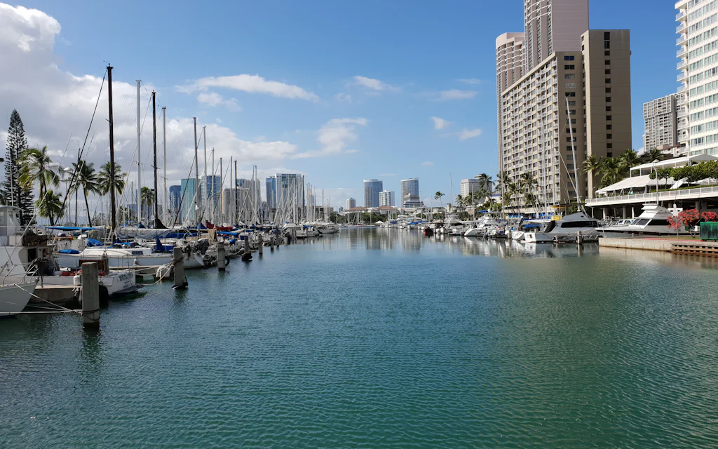 Sailboats in the Ala Wai Yacht Harbor with the Waikiki skyline behind, the harbor that Prince Waikiki overlooks