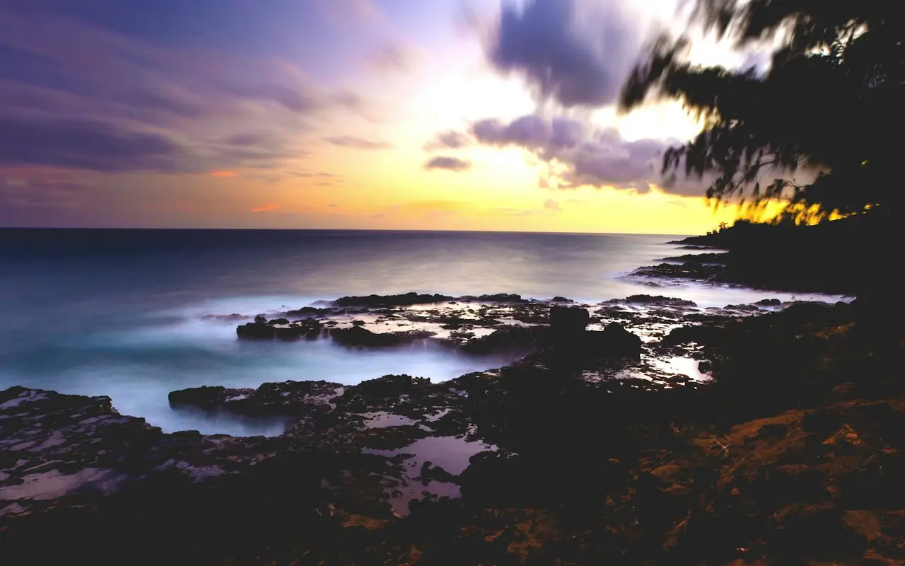 Sunset over the lava shelf at Spouting Horn on Kauai's south shore, the same coast where the blowhole spouts