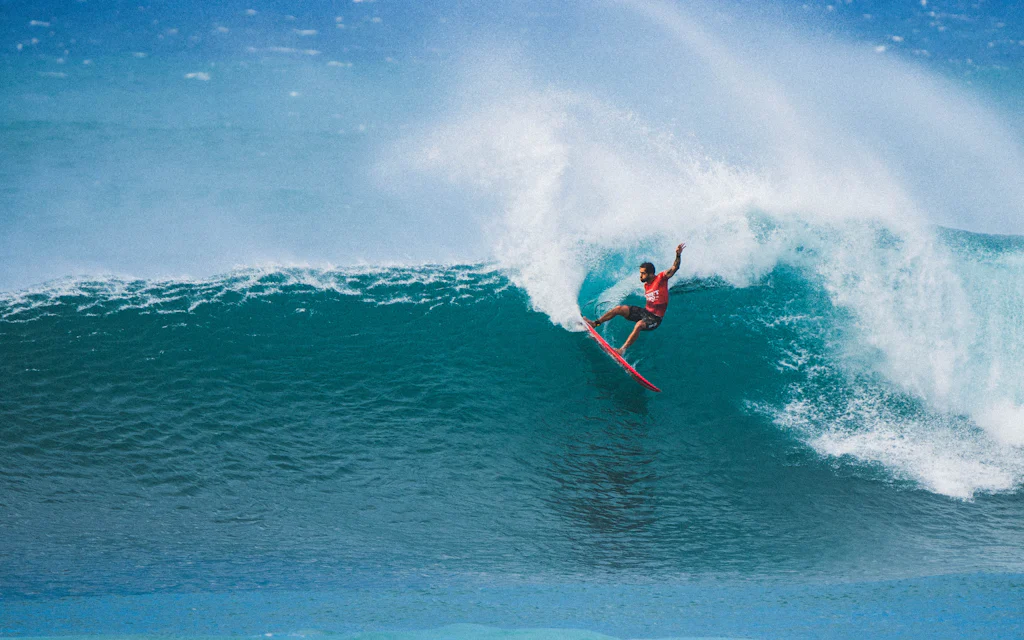 A surfer riding a wave off the coast of Oahu