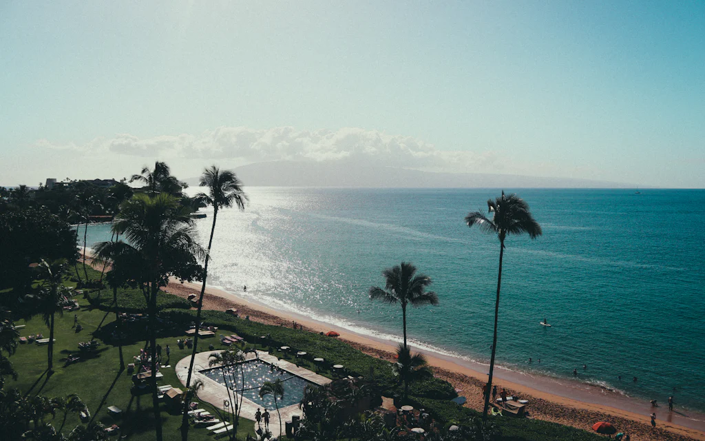 Palm trees over golden sand and bright blue water on a Maui resort beach — the anchor of any things to do in Maui list