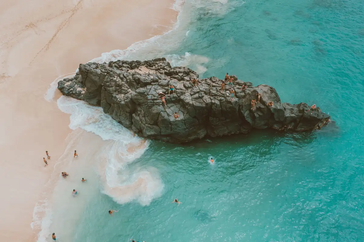 Waimea Bay on Oahu's North Shore in summer, with the famous jump rock and bright blue water